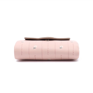 Close-up of pink PU leather wallet featuring floral prints and brown scalloped flap edge
