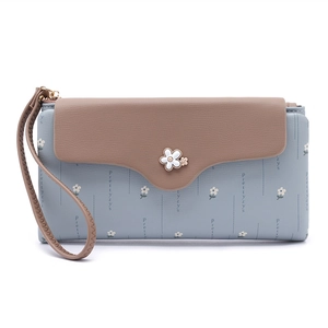 Detail of blue floral long wallet with khaki flap, metal flower clasp and wristlet strap