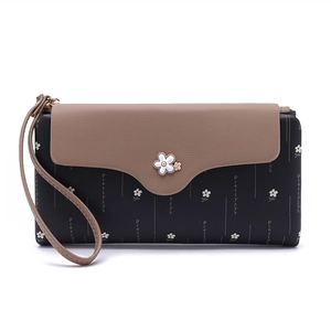 Detail of floral print wallet featuring daisy pattern and elegant flower hardware