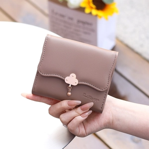 Detailed view of women's short pink leather wallet with rose gold flower snap button