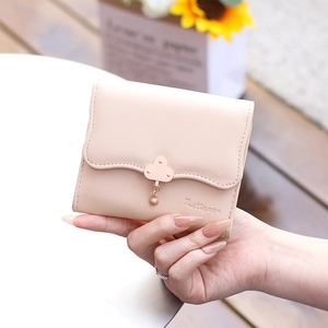 Detailed view of women's trifold wallet with gold cloud clasp and flower pendant charm