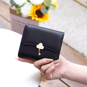 Close-up of black trifold wallet featuring cloud metal clasp and small round pendant charm