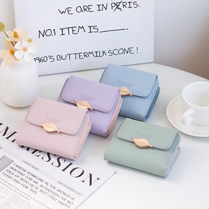 Close-up of matte PU leather women's wallets with elegant golden leaf buckle details