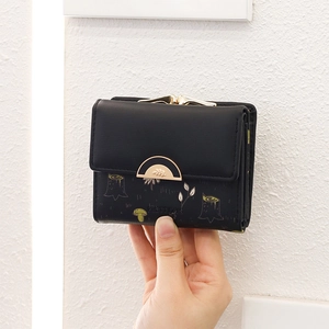 Detail of short black PU leather wallet with golden clasp and forest mushroom print