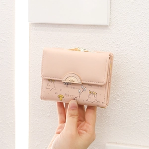 Close-up of pink PU leather wallet with forest prints and metal clasp held in hand