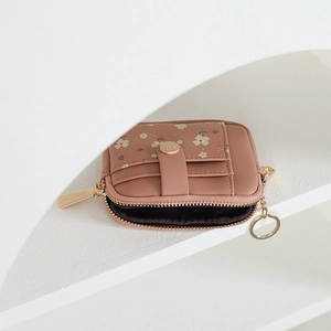Detail view of pink floral mini wallet showing golden zipper and card slot structure