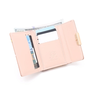 Interior detail of pink trifold wallet with multiple card slots and metal twist lock