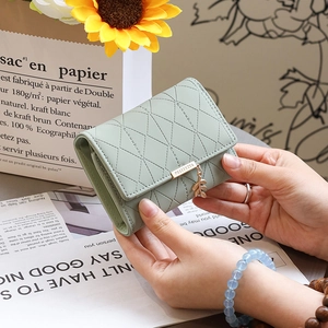 Détail du portefeuille matelassé vert menthe avec pendentif feuille et design pliant