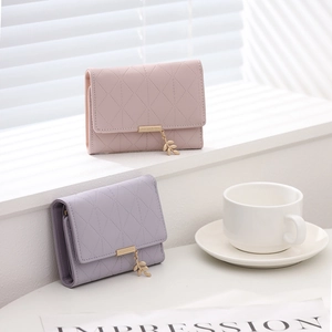 Vue détaillée de portefeuilles matelassés rose et violet avec pendentif feuille