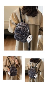 Détail d'un mini sac à dos léopard en peluche avec un charmant pendentif blanc duveteux