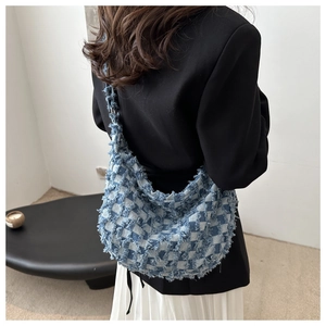 Borsa hobo in denim a scacchi blu e bianchi con frange indossata da modella in nero