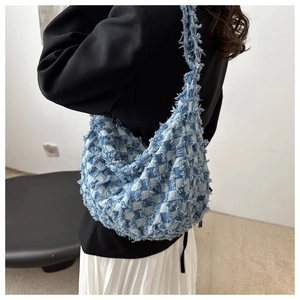 Dettaglio della borsa a tracolla in denim celeste con patchwork a scacchi sfrangiati