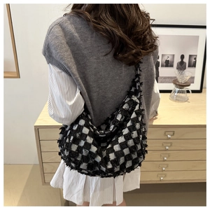 Borsa hobo a scacchi con dettagli di frange e forma a mezzaluna indossata da modella