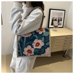 Close-up of 3D floral embroidery on large linen tote bag with sturdy woven handles