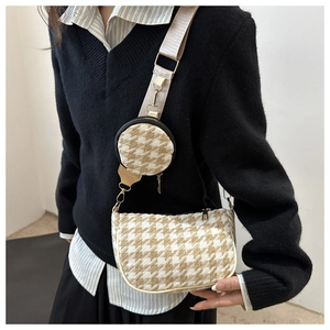 Detail of houndstooth crossbody bag with matching round coin purse on wide strap