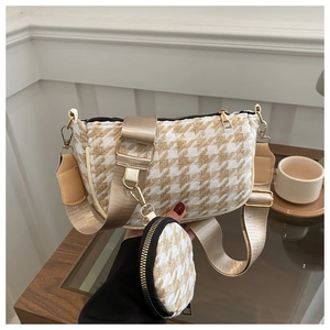 Detail of beige herringbone woven crossbody bag with wide strap and mini round pouch