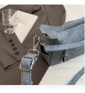 Detail of silver metallic buckles and textured blue fabric on the vintage tote bag