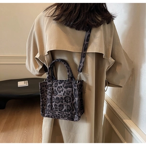 Vue détaillée d'un sac cabas en toile à motif léopard avec bandoulière réglable sur modèle