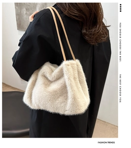 Detail view of cream faux fur tote bag with leather straps on model shoulder