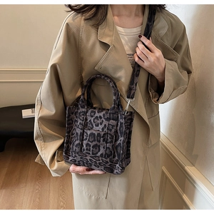 Détail du sac cabas en toile léopard avec poignées et bandoulière réglable amovible