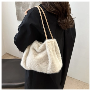 Detail of soft beige faux fur texture and slim leather shoulder straps on a plush bag