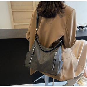 Détail d'un grand sac cabas gris foncé avec fermetures éclair et poches latérales
