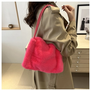 Close-up of hot pink faux fur shoulder bag with soft texture and leather strap detail