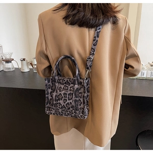Sac fourre-tout à motif léopard porté en bandoulière dans un décor de café