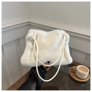 Detail of soft cream faux fur texture and dual slim straps on a plush shoulder tote bag