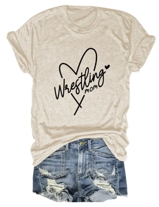 Flat lay of an oat-colored Wrestling Mom heart print T-shirt paired with ripped denim shorts