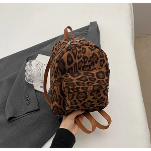 Détail macro d'un mini sac à dos en peluche à motif léopard avec lanières en cuir