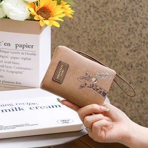 Close-up of brown PU leather wallet featuring a cute giraffe print and zipper wristlet strap