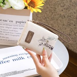 Detail of cream PU leather wallet featuring a cute giraffe print and wristlet strap