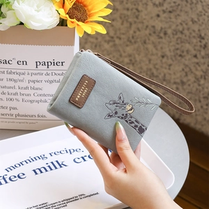 Detail of blue PU leather wallet with giraffe illustration and wrist strap on a table