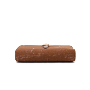 Détail du portefeuille en cuir marron avec boucle feuille dorée et motif imprimé