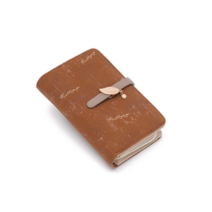 Détail d'un portefeuille en cuir marron avec pendentif feuille dorée et fermeture éclair
