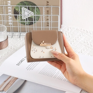Close-up of floral PU leather short wallet featuring gold leaf buckle and charm detail