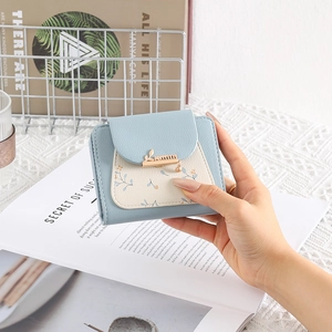 Detailed view of women's bi-fold PU leather wallet with leaf metal clasp and floral print
