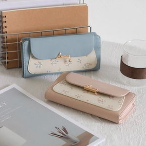 Detail of floral patchwork leather wallets with gold bird clasp and zipper closure