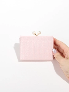 Detail of light pink textured wallet with pearl clasp held in hand on white background