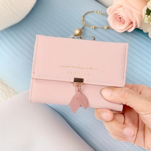 Detail von rosa Blattanhänger und Goldlogo auf Saffiano-Lederbörse für Damen