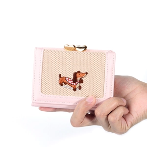 Détail du portefeuille rose à trois volets avec broderie teckel et fermoir cœur doré