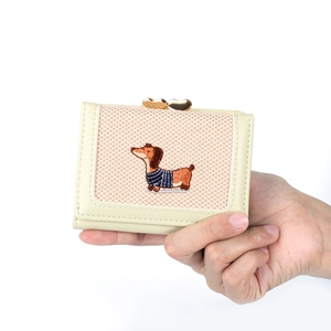 Détail du fermoir en cœur et de la broderie teckel sur le petit portefeuille crème