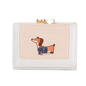 Détail d'un portefeuille en cuir crème avec broderie teckel et fermoir cœur doré