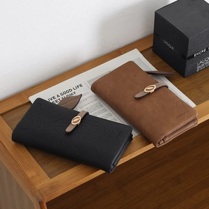 Détail de portefeuilles longs vintage noir et marron avec boucle feuille en métal