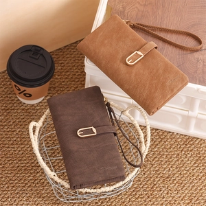 Detail view of long PU leather wallets with metal buckle and woven hand strap texture