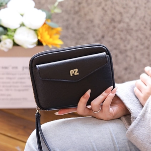 Detail of black pebbled leather passport bag with gold PZ logo and zip wristlet strap