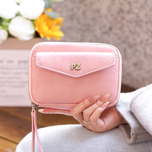 Detail of pink leather passport holder with gold PZ logo and detachable wrist strap