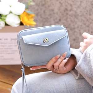 Detail of light blue faux leather travel passport bag with PZ logo and wrist strap