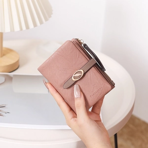 Gros plan du portefeuille en cuir rose avec boucle feuille dorée et logo de marque